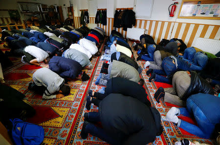 Muslims pray during Friday prayers at the Turkish Kuba Camii mosque located near a hotel housing refugees in Cologne's district of Kalk, Germany, October 14, 2016. REUTERS/Wolfgang Rattay