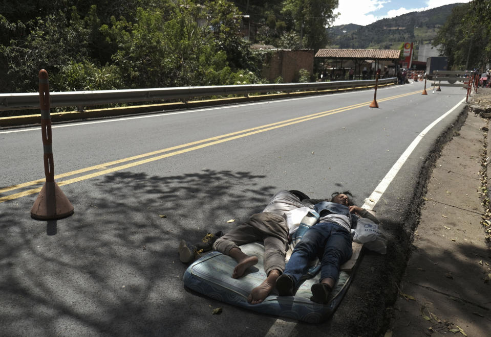 Venezuelan migrants sleep on a mattress on the side of the highway in Pamplona, Colombia, Wednesday, Oct. 7, 2020, a few hours away by car from the Venezuelan border. Once the migrants reach their destination, a new list of worries sets in: Colombia’s unemployment rate rose from 12% in March to almost 16% in August; those who can’t afford to pay rent are being evicted from their homes; and more than half of all Venezuelans in Colombia have no legal status. (AP Photo/Ferley Ospina)