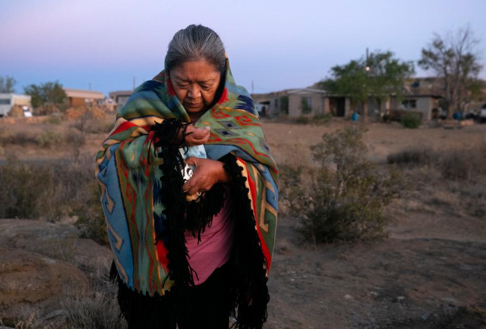Beatrice Norton prays at sunrise while taking ground white corn in her hand in front of her home in Oraibi on the Hopi Reservation on Sept. 12, 2020. Corn is an integral part of Hopi culture and religion. Norton prays this way each morning.