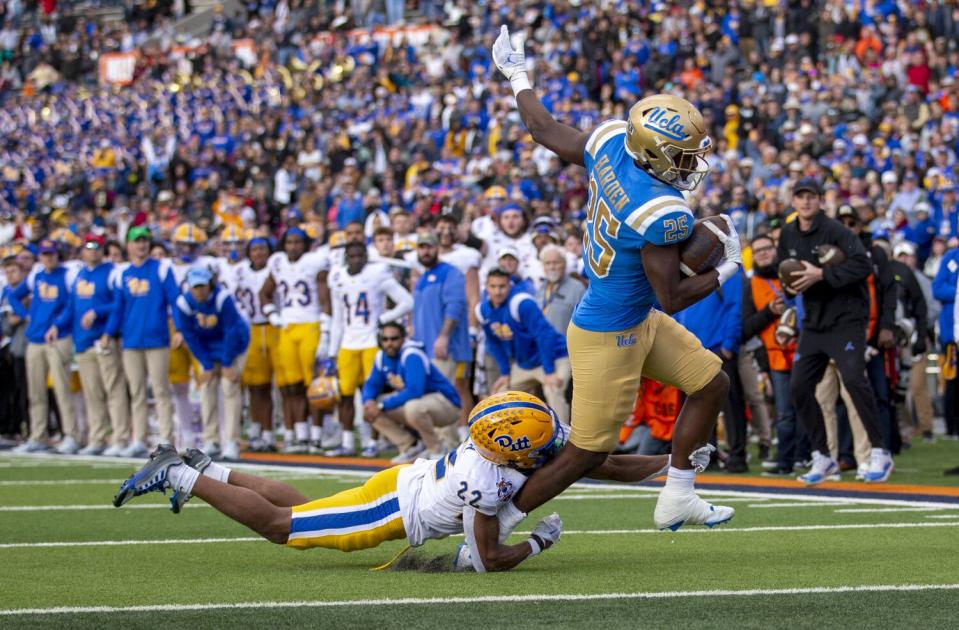 UCLA running back T.J. Harden breaks the tackle of Pittsburgh defensive back P.J. O'Brien.