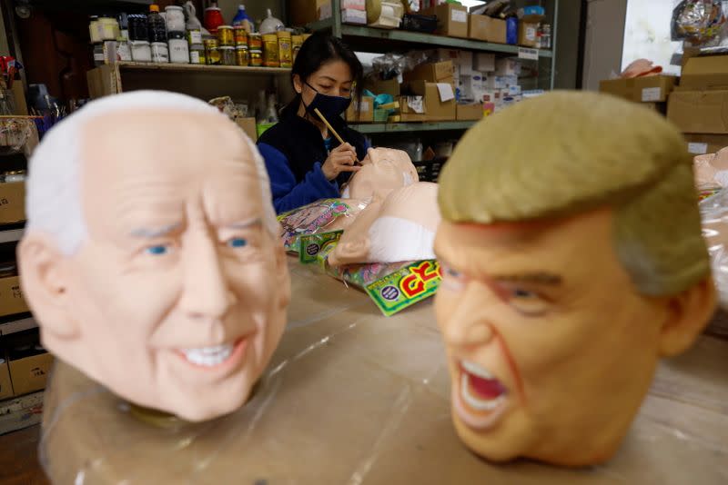 A worker of Ogawa Studios, a mask and toy making company, works next to masks depicting U.S. President Donald Trump and U.S. President-elect Joe Biden after Biden was called winner of the presidential election, at its studio in Saitama, Japan