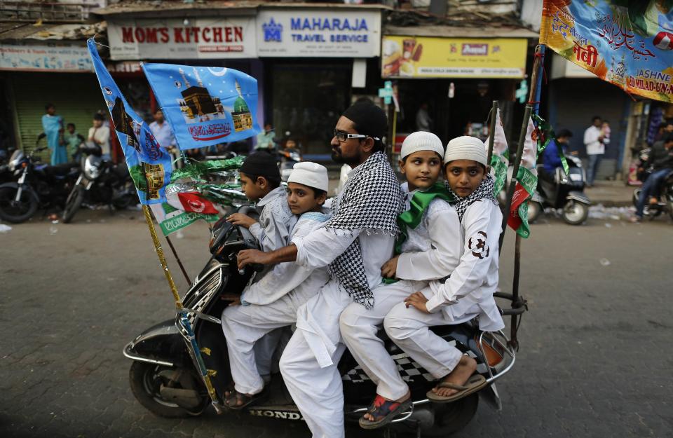 Muslims ride on a scooter on their way to participate in a procession to mark Eid-e-Milad-ul-Nabi, or birthday celebrations of Prophet Mohammad in Mumbai