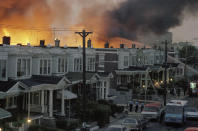 FILE - In this May, 1985 file photo, scores of row houses burn in a fire in the west Philadelphia neighborhood. Police dropped a bomb on the militant group MOVE's home on May 13, 1985 in an attempt to arrest members, leading to the burning of scores of homes in the neighborhood. Philadelphia Mayor Jim Kenney said in a statement Thursday, May 13, 2921, that Health Commissioner Dr. Thomas Farley decided to cremate and dispose of the remains several years ago. Farley was forced to resign after Kenney said he learned human remains from the 1985 bombing of the headquarters of a Black organization had been cremated and disposed of without notifying family members. (AP Photo/File)