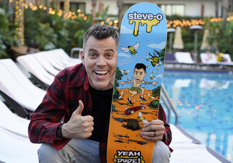Steve-O, a cast member in the film "Jackass Forever," holds u his skateboard as he poses for a portrait at The Hollywood Roosevelt pool, Thursday, Jan. 27, 2022, in Los Angeles. (AP Photo/Chris Pizzello)