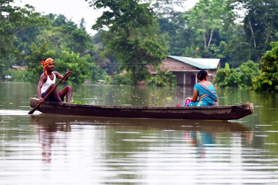 A alood affected family are transported on a boat towards a safer place at Baghmari village in Nagaon District of Assam. (Photo credit should read Anuwar Ali Hazarika/Barcroft Media via Getty Images)
