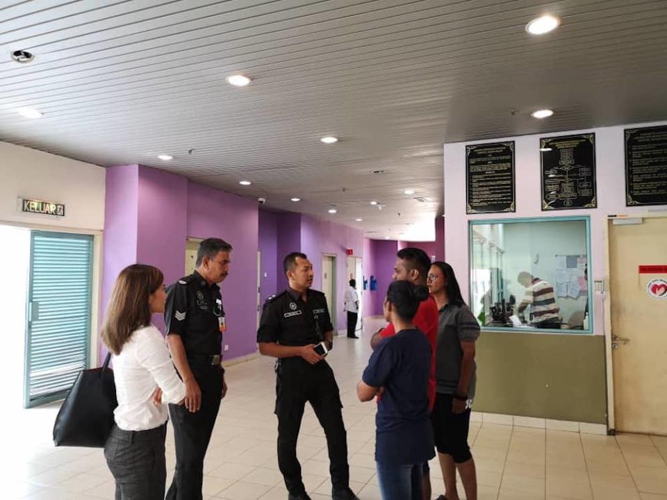 Melissa Sasidaran (white shirt) from Lawyers for Liberty (LFL) speaks to policemen at Hospital Sungai Buloh. — Picture via Twitter/Melissa_ms