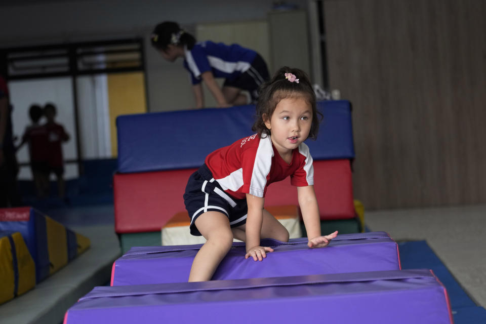 Rylae-Ann Poulin attends physical education class at Ruamrudee International School in Bangkok, Thailand, Friday, Jan. 13, 2023. Rylae-Ann’s disease was caused by mutations in a gene needed for an enzyme that helps make neurotransmitters like dopamine and serotonin, the body’s chemical messengers. A one-time treatment delivered a working version of the gene. (AP Photo/Sakchai Lalit)