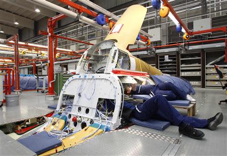 Engineers Bianca Gust (R) and Juergen Schweigard work in the Avionic Bay of an Eurofighter Typhoon while setting up all component parts of an Eurofighter at the headquarters of Military Air Systems Centre Cassidian in Manching near Ingolstadt, southern Germany in this February 28, 2013 file photo. REUTERS/Michaela Rehle/Files