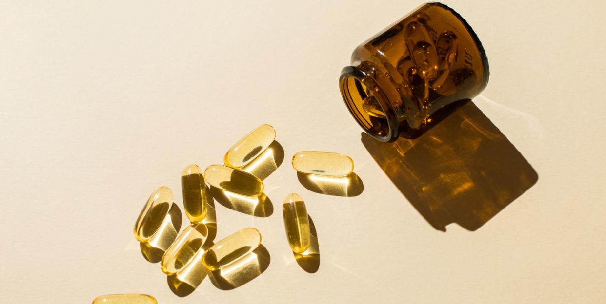 omega 3 fish oil capsules and a glass bottle on a beige background