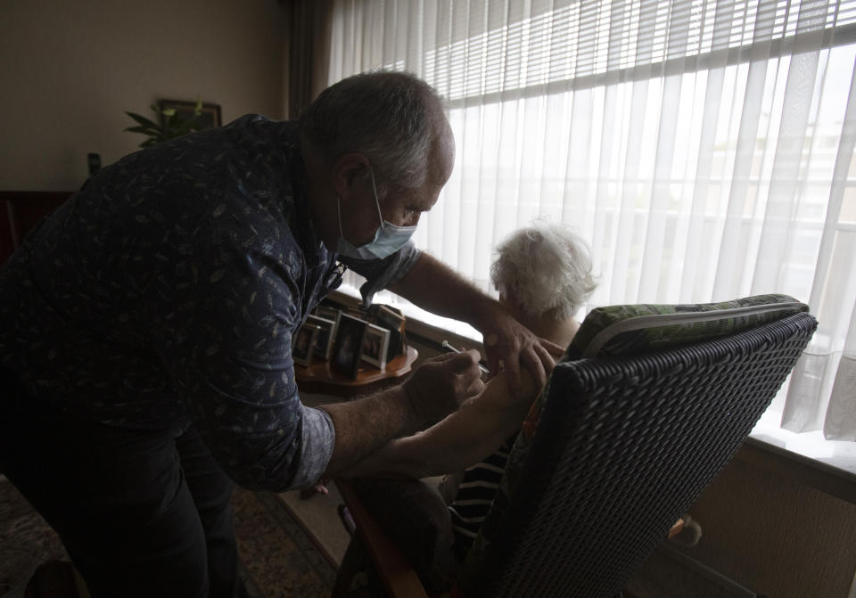 FILE - In this May 6, 2021 file photo, Belgian doctor Peter Theerens administers the Johnson & Johnson COVID-19 vaccine to an elderly patient during a house call in Antwerp, Belgium. The government warned Thursday, Oct. 21, 2021 that Belgium could well be on the cusp of another major surge in COVID-19 cases despite its high rate of vaccinations. (AP Photo/Virginia Mayo, File)