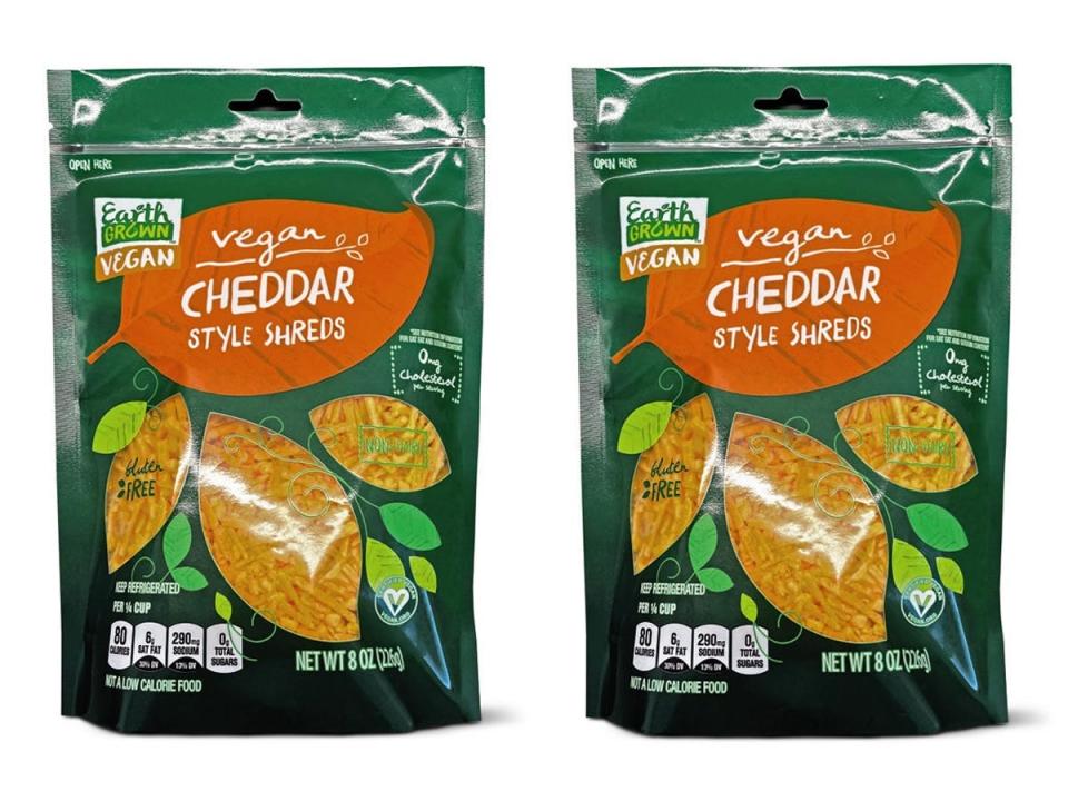 Aldi photos of green and orange packaging of vegan cheddar shreds against white background