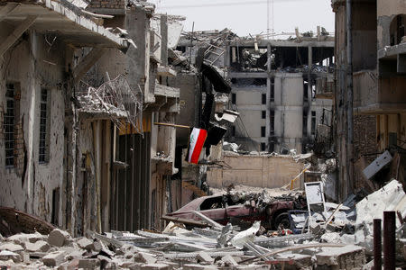 FILE PHOTO: An Iraqi flag is seen amid destroyed buildings during fighting between Iraqi forces and Islamic State militants in the Old City of Mosul, Iraq, July 4, 2017. REUTERS/Ahmed Saad/File Photo