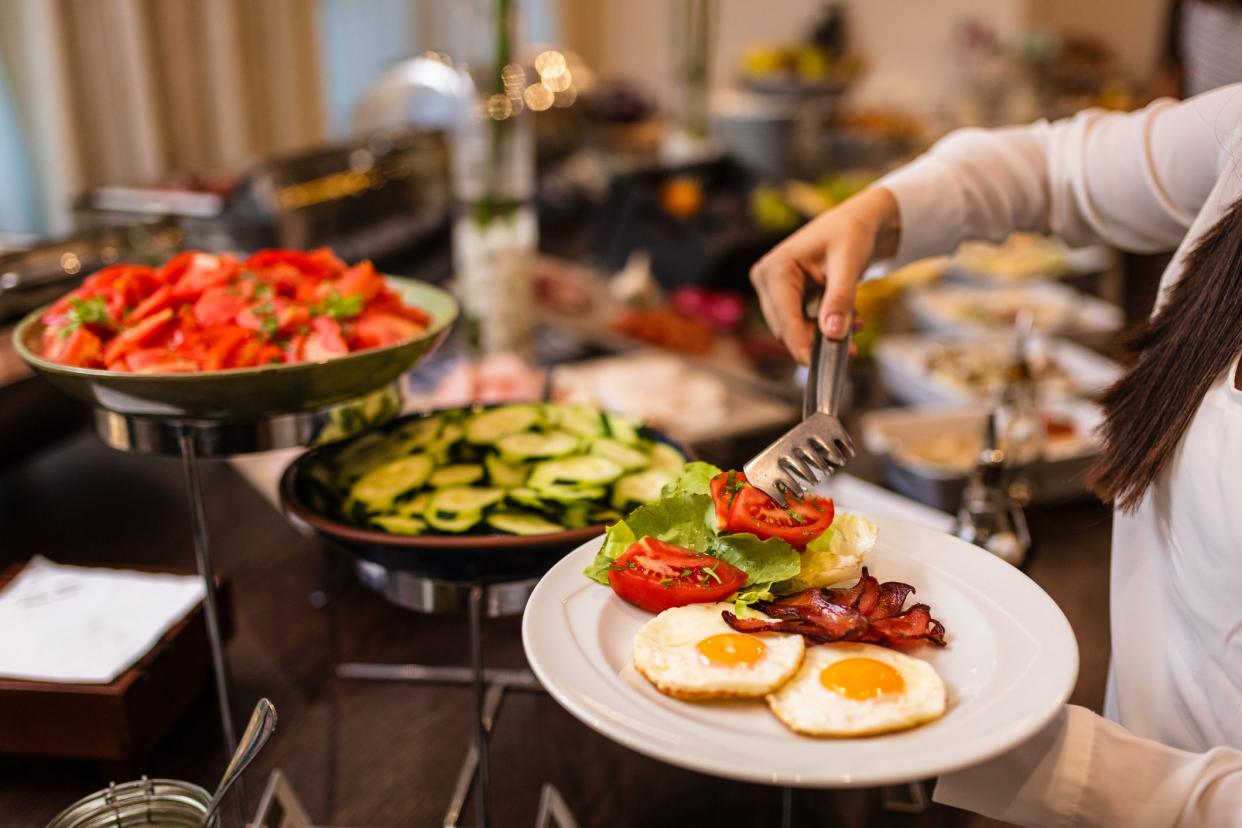 Unrecognizable person choosing canape from a sideboard at a banquet