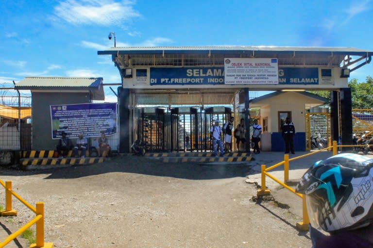 Employees from the Freeport-McMoRan mine stand at the entrance of a bus terminal in Timika, Papua