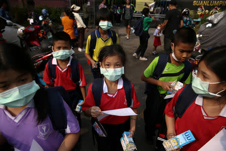 Student wear masks as they wait to be picked up, as classes in over 400 Bangkok schools have been cancelled due to worsening air pollution, at a public school in Bangkok, Thailand, January 30, 2019. REUTERS/Athit Perawongmetha