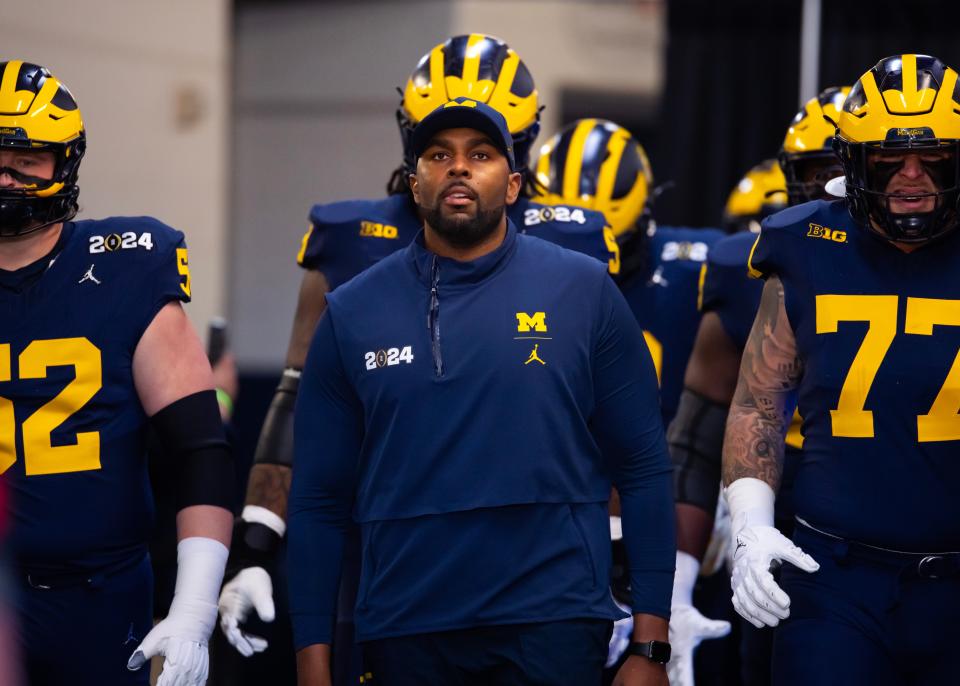 Michigan offensive coordinator Sherrone Moore walks to the field ahead of the College Football Playoff national championship game at NRG Stadium.