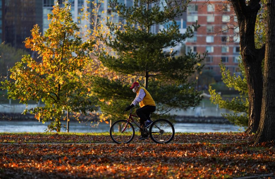 (201115) -- NEW YORK, Nov. 15, 2020 (Xinhua) -- A man wearing a face mask rides at a park in New York, the United States, Nov. 14, 2020.   The United States has reported more than 10.8 million COVID-19 cases in total with the death toll from the disease exceeding 245,000 as of Saturday afternoon, showed a tally by Johns Hopkins University. (Xinhua/Wang Ying) (Xinhua/Wang Ying via Getty Images)