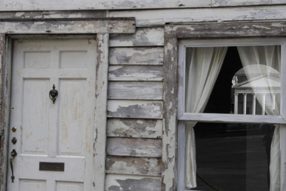 Piazza del Plebiscito Square is reflected on a window of a the house of U.S. civil rights campaigner Rosa Parks, rebuilt by artist Ryan Mendoza, on display in Naples, Italy, Tuesday, Sept. 15, 2020. The rundown, paint-chipped Detroit house where Parks took refuge after her famous bus boycott is going on display in a setting that couldn't be more incongruous: the imposing central courtyard of the 18th century Royal Palace in Naples. (AP Photo/Gregorio Borgia)