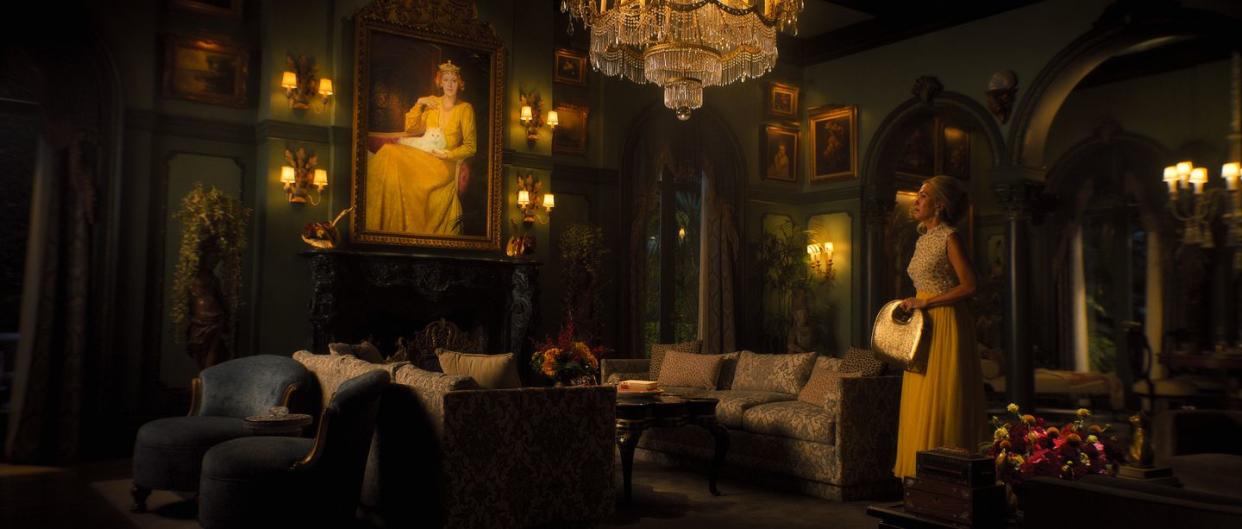 a person in a dress in a room with a chandelier