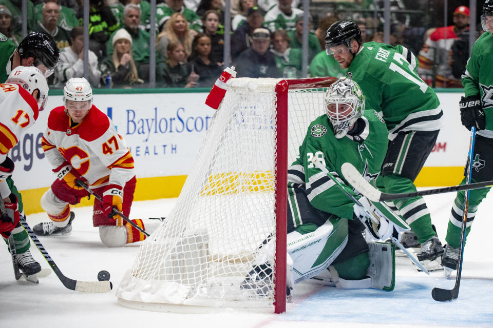 Calgary Flames center Yegor Sharangovich (17) attempts to get the puck to a teammate as Dallas Stars goaltender Jake Oettinger (29) guards the net during the second period of an NHL hockey game, Friday, Nov. 24, 2023, in Dallas. (AP Photo/Emil T. Lippe)