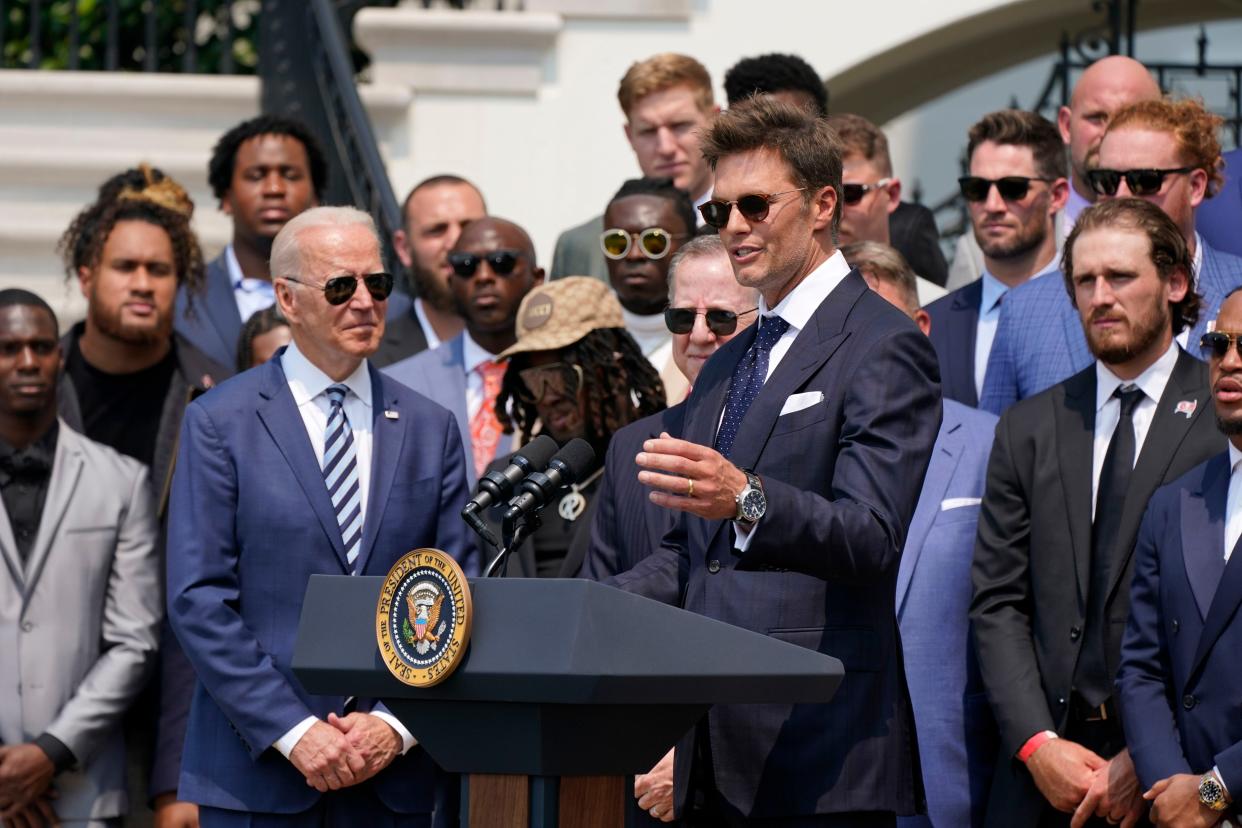 President Joe Biden, surrounded by members of the Tampa Bay Buccaneers, listens as Tampa Bay Buccaneers quarterback Tom Brady speaks during a ceremony on the South Lawn of the White House, in Washington on Tuesday, July 20, 2021, where Biden honored the Super Bowl Champion Tampa Bay Buccaneers for their Super Bowl LV victory.