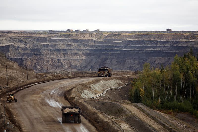 FILE PHOTO: Giant dump trucks haul raw tar sands at the Suncor tar sands mining operations near Fort McMurray.