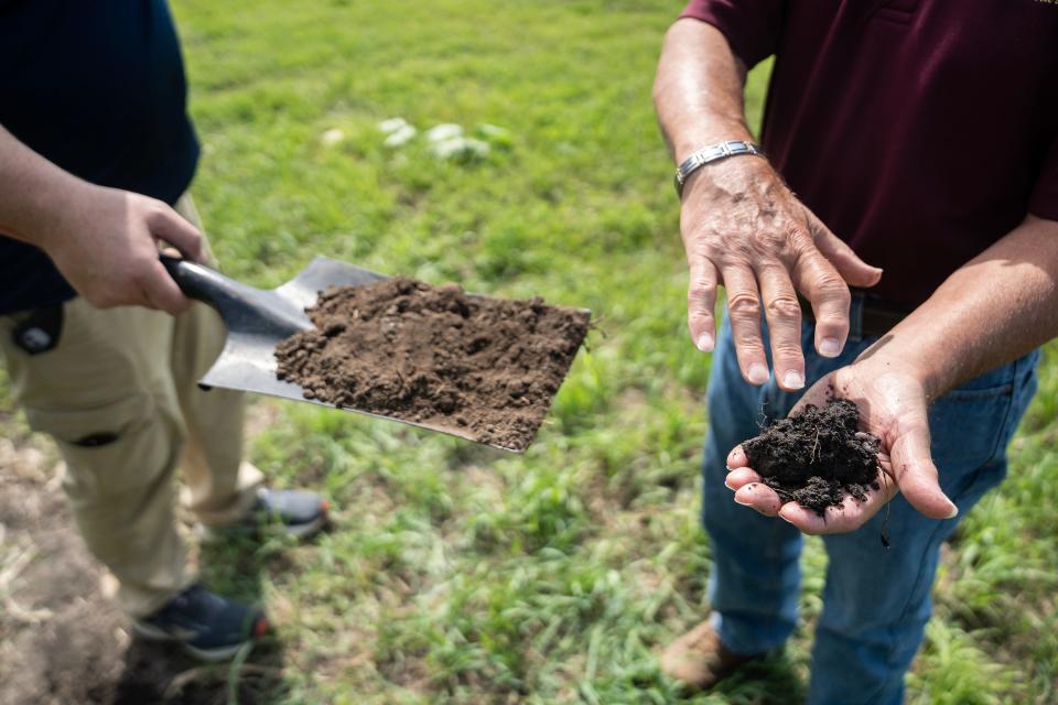 Jerry Hatfield, a retired U.S. Department of Agriculture scientist, and Ken Wacha, a research hydrologist at the National Laboratory for Agriculture and the Environment, show the difference in soil between a field that has been maintained to reduce carbon loss vs. one that has not, on Wednesday, July 19, 2023. The darker soil on the right is healthier soil that has retained more carbon.