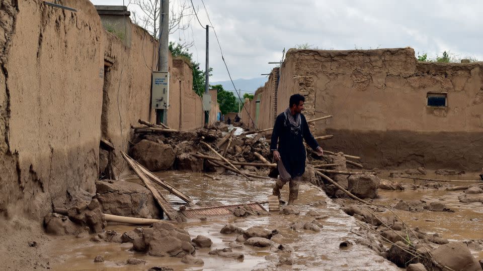 An Afghan man walks near his damaged home after heavy flooding in Baghlan province Saturday. - Mehrab Ibrahimi/AP