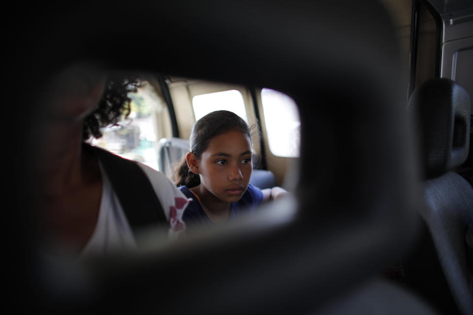 En esta imagen, tomada el 2 de septiembre de 2018, la venezolana Angelis, de 10 años, sentada en un auto con su madre, Sandra Cádiz, tras conseguir un transporte gratuito hasta la siguiente ciudad, Lebrija, en Colombia, en su viaje a Perú. Un agente de policía se ofreció a pararles un auto y un hombre en un viejo Chevrolet Samurai accedió a llevarlas. (AP Foto/Ariana Cubillos)