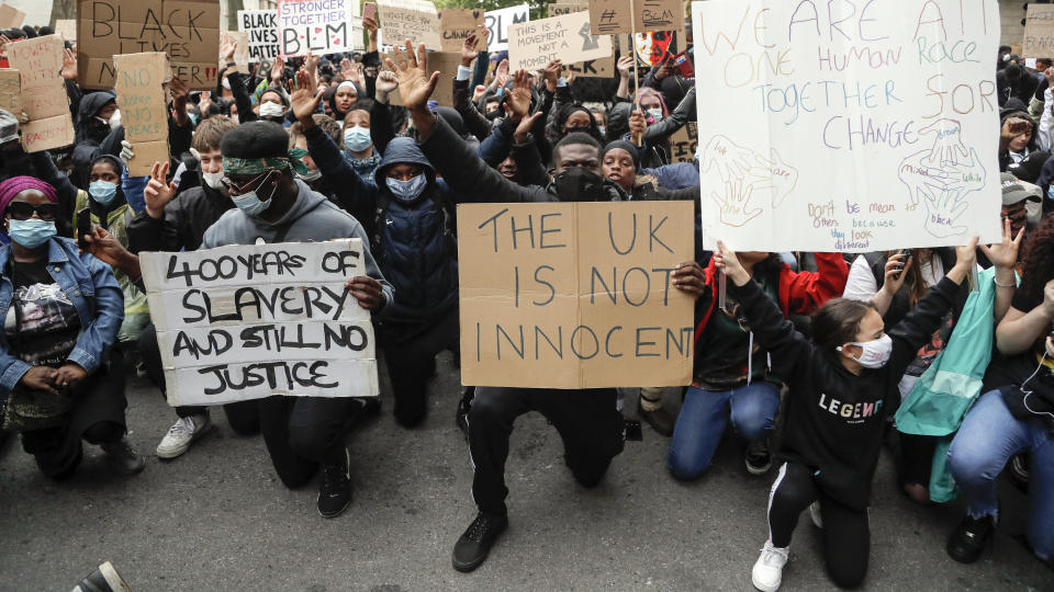 FILE - In this file photo dated Saturday, June 6, 2020, demonstrators gather outside Downing Street during a Black Lives Matter march in London. A government inquiry, by a panel of experts, has concluded Wednesday March 31, 2021, that there is racism in Britain, but it’s not a systematically racist country that is “rigged” against non-white people, though many ethnic-minority Britons greeted that claim with skepticism. (AP Photo/Frank Augstein, FILE)