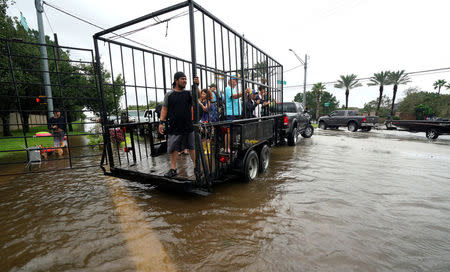 A group of people are shuttled to dry ground in a trailer after being evacuated by boat from the Hurricane Harvey floodwaters in Houston, Texas August 29, 2017. REUTERS/Rick Wilking