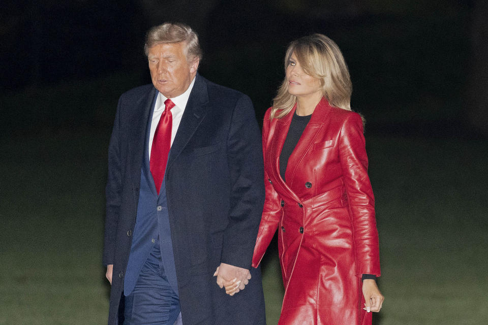 President Donald Trump and first lady Melania Trump walk on the South Lawn of the White House in Washington, Saturday, Dec. 5, 2020, after stepping off Marine One. Trump is returning from a rally for U.S. Senate candidates David Perdue and Kelly Loeffler in Georgia. (AP Photo/Patrick Semansky)