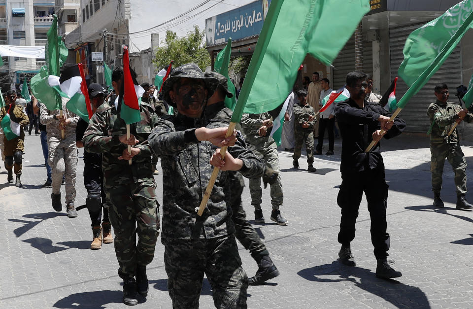 Hamas supporters paint heir faces while mach with their green and national flags during a protest against Israel's plan to annex parts of the West Bank and U.S. President Donald Trump's mideast initiative, after Friday prayer at the main road of Khan Younis City, Gaza Strip, Friday, June 26, 2020. (AP Photo/Adel Hana)