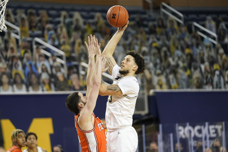 Michigan forward Brandon Johns Jr. (23) shoots on Illinois forward Giorgi Bezhanishvili (15) in the second half of an NCAA college basketball game in Ann Arbor, Mich., Tuesday, March 2, 2021. (AP Photo/Paul Sancya)