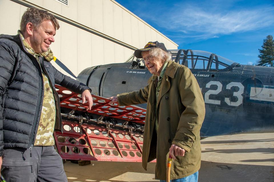 Russell Phipps, right, of Hopkinton, a 101-year-old World War II veteran, chats with American Heritage Museum President Rob Collings beside an SBD Dauntless aircraft, the primary carrier-based dive bomber used by the Navy during World War II, Dec. 29, 2022.