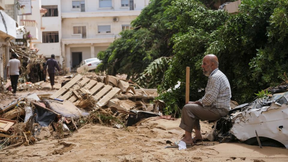 A man sits on a damaged car, after a powerful storm and heavy rainfall hit eastern Libya, on Tuesday. - Esam Omran Al-Fetori/Reuters