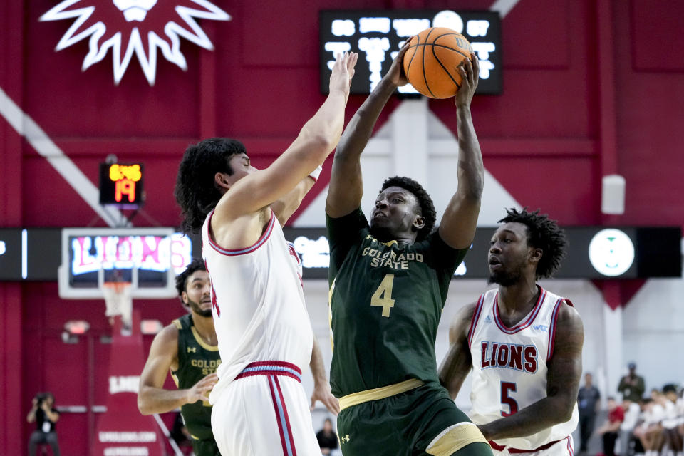 Colorado State guard Isaiah Stevens, center, shoots from between Loyola Marymount forward Keli Leaupepe, left, and guard Justin Wright during the second half of an NCAA college basketball game Friday, Dec. 22, 2023, in Los Angeles. (AP Photo/Ryan Sun)