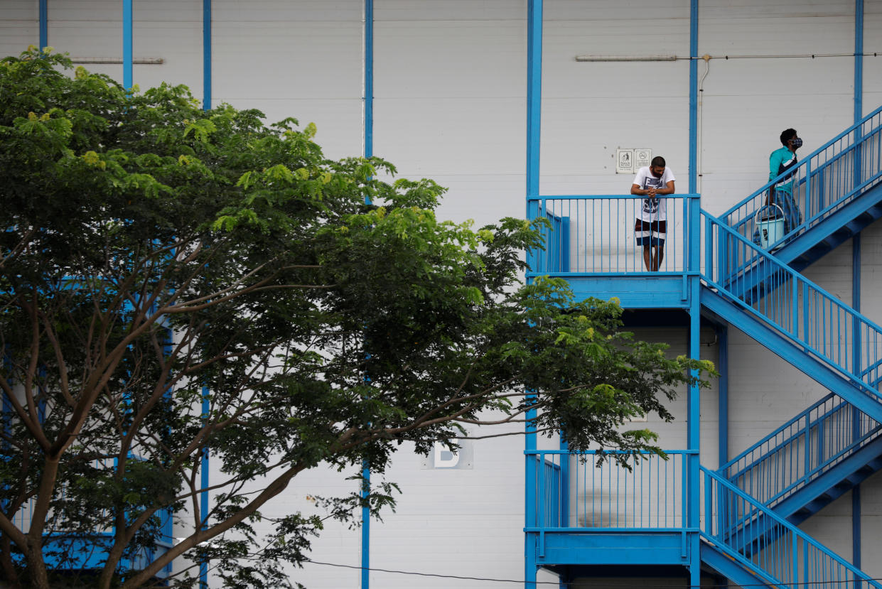 Migrant workers look on from their dormitory in Singapore.