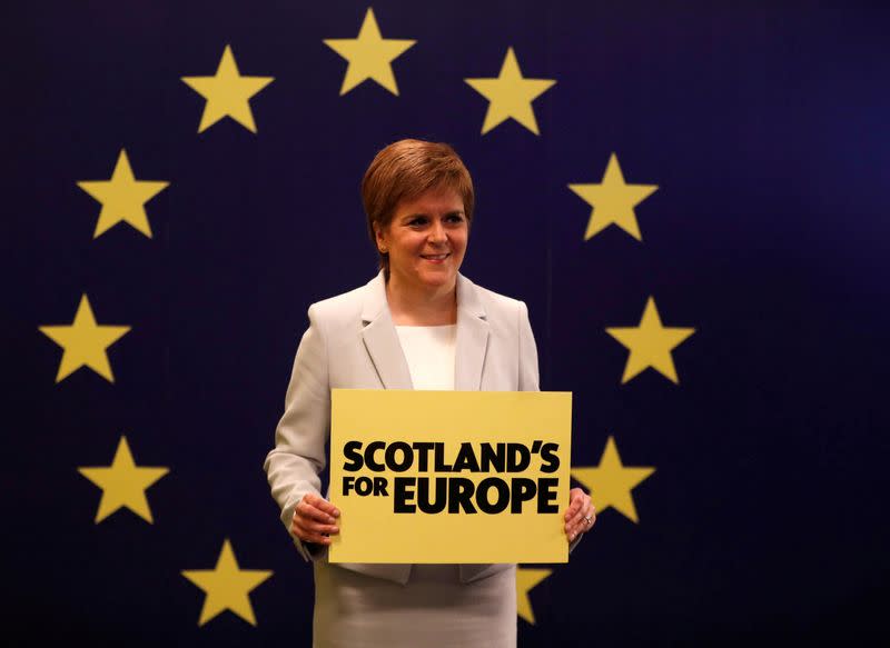 FILE PHOTO: Scotland's First Minister Nicola Sturgeon stands in front of a European Union flag at the Scottish National Party (SNP) conference in Edinburgh