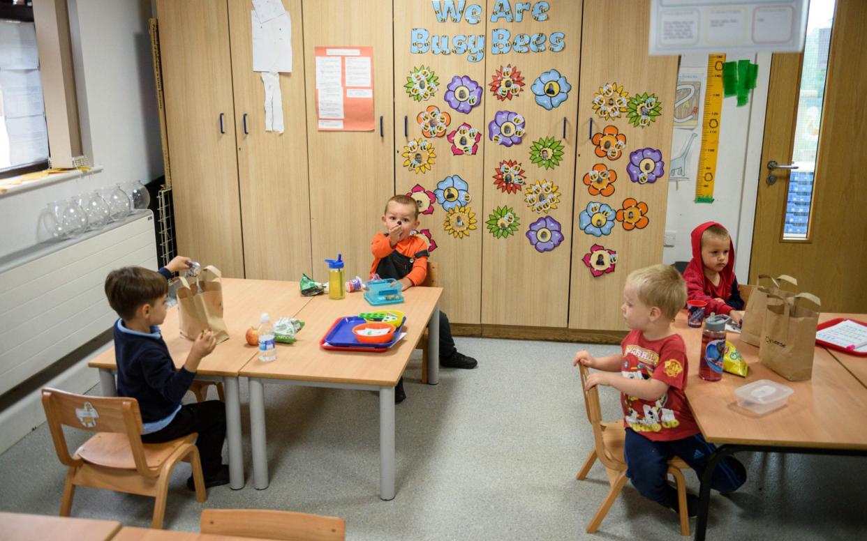 Nursery children have their lunch whilst sitting apart in order to minimise the risk of passing on Coronavirus at Willowpark Primary Academy 