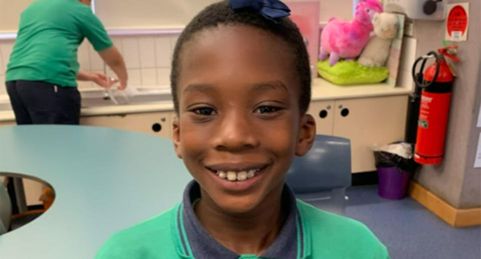 De-Young smiles for a photo in his school uniform.