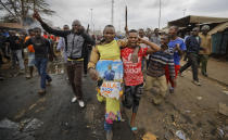 <p>A protester wearing a woman’s dress as a joke, on which is pinned a banner of opposition candidate Raila Odinga, who they support, walks towards police before clashes erupted in the Kawangware area of Nairobi, Kenya Thursday, Aug. 10, 2017. (Photo: Ben Curtis/AP) </p>