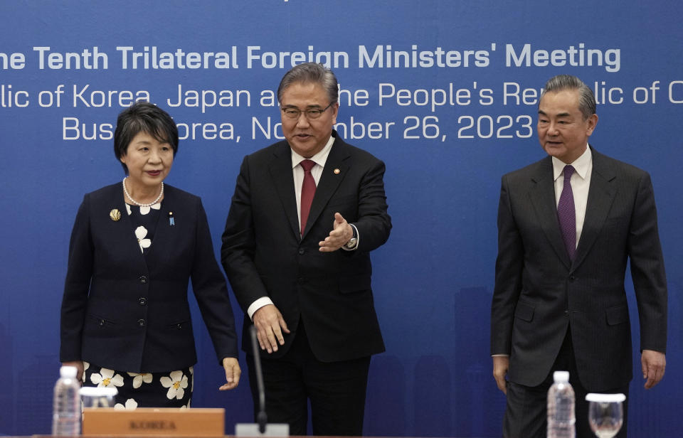 South Korean Foreign Minister Park Jin, center, escorts Chinese Foreign Minister Wang Yi, right, and Japanese Foreign Minister Yoko Kamikawa, left, prior to the trilateral foreign ministers' meeting in Busan, South Korea, Sunday, Nov. 26, 2023. (AP Photo/Ahn Young-joon, Pool)