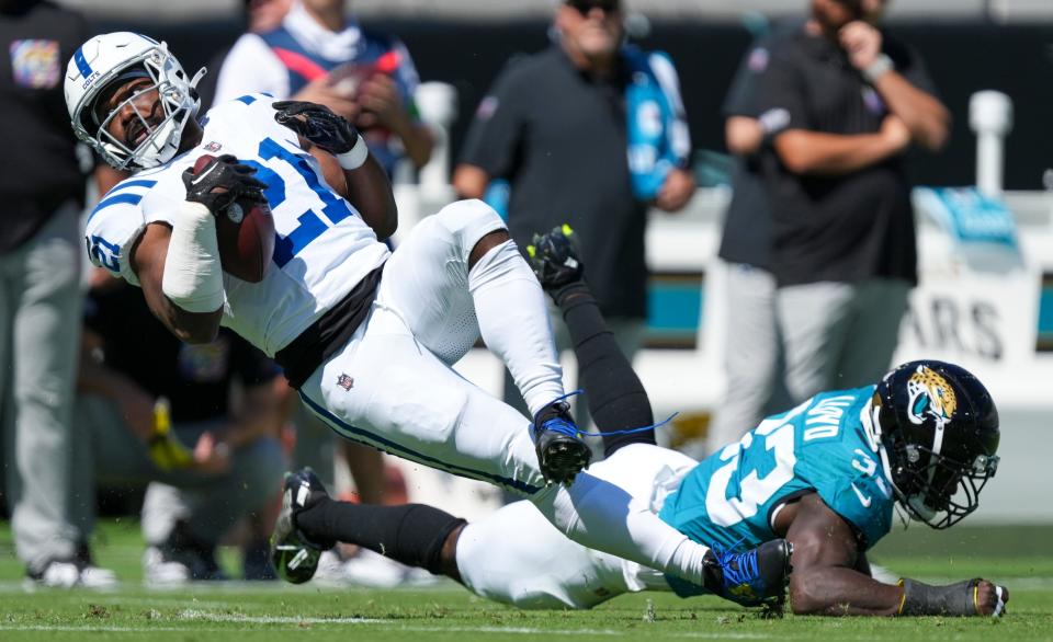 Indianapolis Colts running back Zack Moss (21) rolls off a tackle by Jacksonville Jaguars linebacker Devin Lloyd (33) during game action at EverBank Stadium on Sunday, Oct 15, 2023, in Jacksonville.