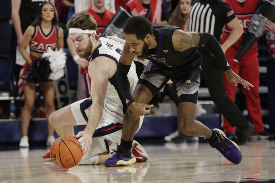 Gonzaga forward Drew Timme, left, and Washington guard PJ Fuller II go after the ball during the first half of an NCAA college basketball game, Friday, Dec. 9, 2022, in Spokane, Wash. (AP Photo/Young Kwak)