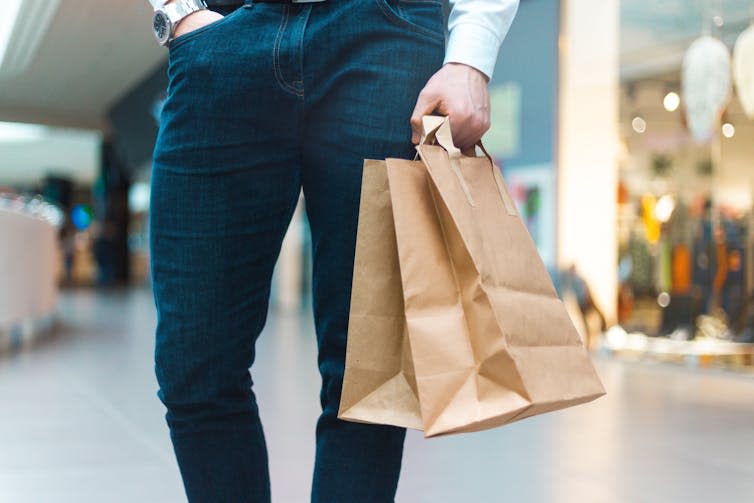 man with shopping bags outside a shop