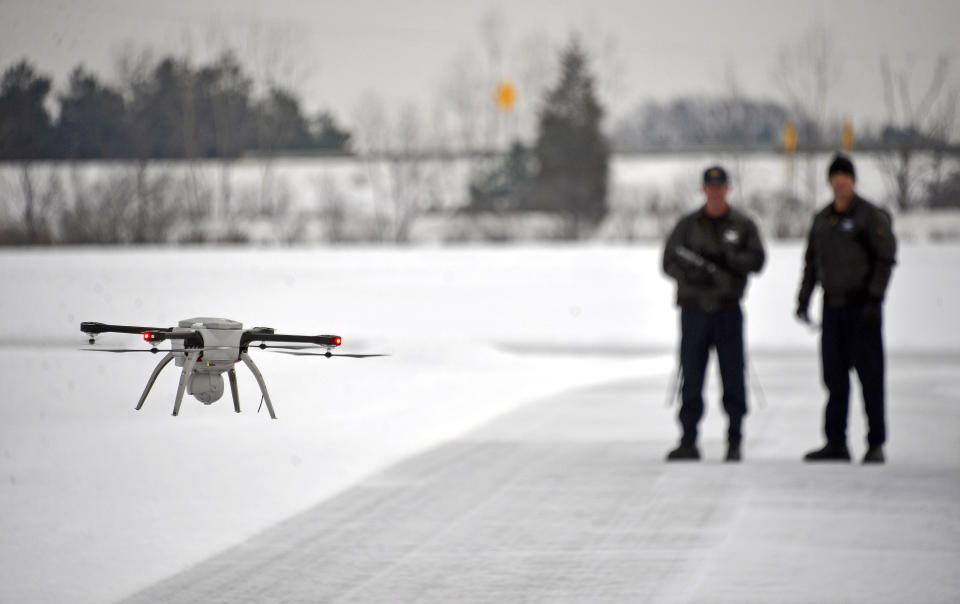 FILE – In this Jan. 15, 2015, file photo, Michigan State Police Sgt. Matt Rogers and Trooper Don Zinz bring an Aeryon SkyRanger drone in for a landing during a demonstration of the agency's new Unmanned Aircraft System at the Michigan State Police training track in Dimondale, Mich. More than a year after the U.S. Interior Department grounded hundreds of Chinese-made drones it was using to track wildfires and monitor dams and wildlife, the future of drone use by the federal government remains unmapped. The latest complication: Legislation moving through Congress that would block the U.S. government from using drones made in China. (Dale G. Young/Detroit News via AP)