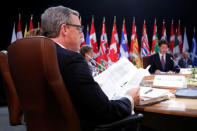 Saskatchewan Premier Brad Wall (L) looks at papers as Canada's Prime Minister Justin Trudeau (2nd R) speaks during the First Ministers’ meeting in Ottawa, Ontario, Canada, December 9, 2016. REUTERS/Chris Wattie