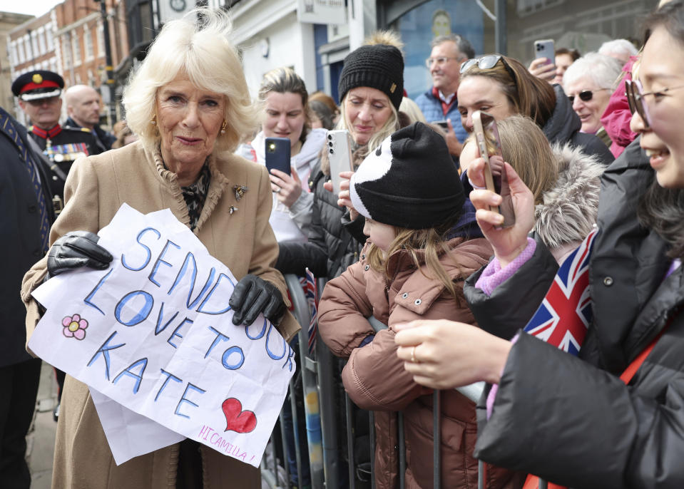 FILE - Britain's Queen Camilla receives a message of support for Princess Catherine, during her visit to the Farmers' Market in Shrewsbury, England, Wednesday March 27, 2024. Camilla has emerged as one of the monarchy’s most prominent emissaries. Increasing her schedule of appearances, the queen played a crucial role in keeping the royal family in the public eye. (Chris Jackson/Pool via AP, File)