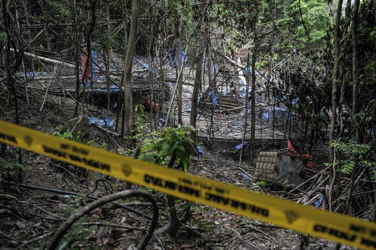 Malaysian police cordon off an abandoned migrant camp used by human-traffickers in a jungle clearing at Bukit Wang Burma, on May 26, 2015